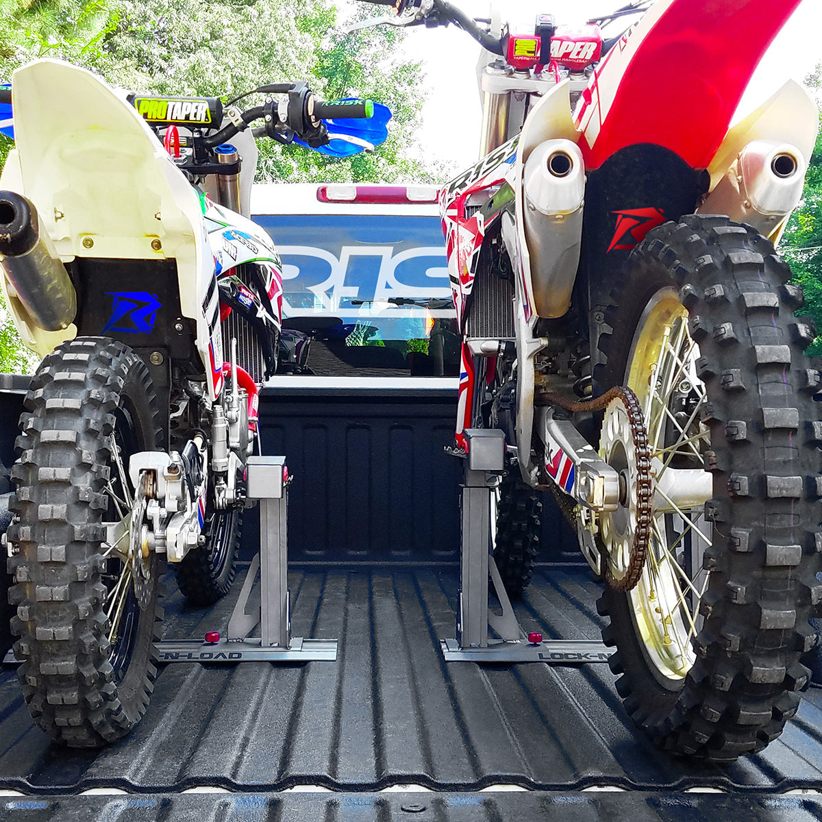 two dirt bikes secured into a truck bed using two Lock-N-Load Pro Transport systems by Risk Racing